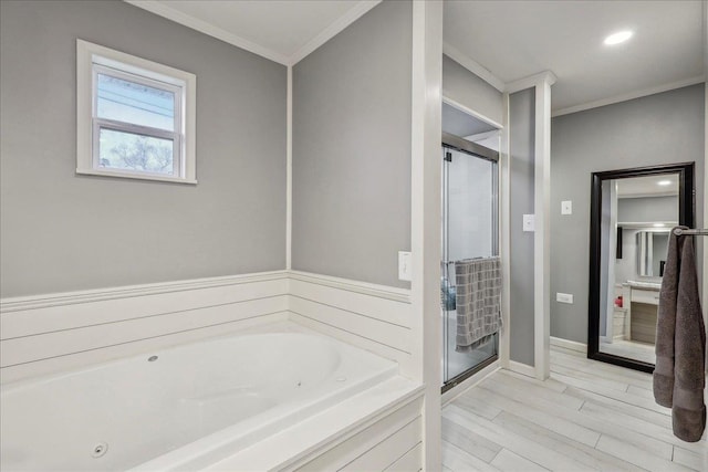 bathroom featuring ornamental molding, a jetted tub, wood finished floors, a shower stall, and baseboards