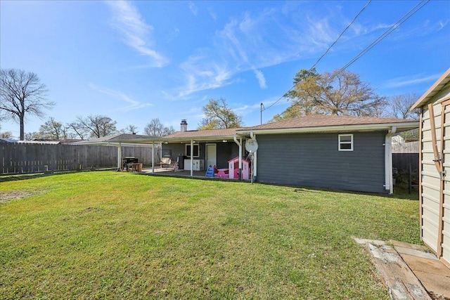 rear view of house with a lawn, a fenced backyard, and a patio area