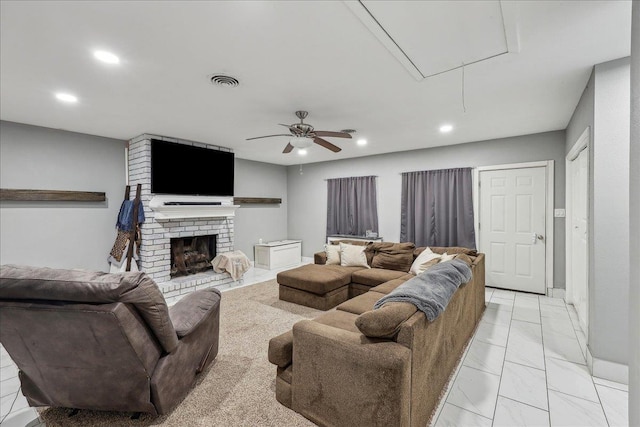 living room with a ceiling fan, visible vents, attic access, recessed lighting, and a brick fireplace