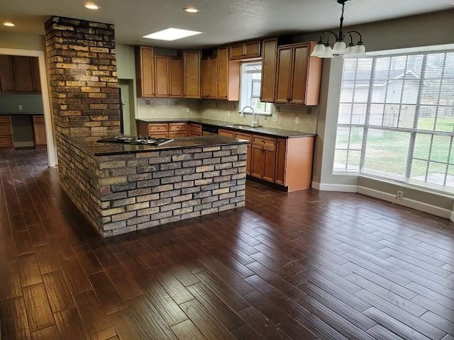 kitchen with gas cooktop, sink, pendant lighting, and dark wood-type flooring