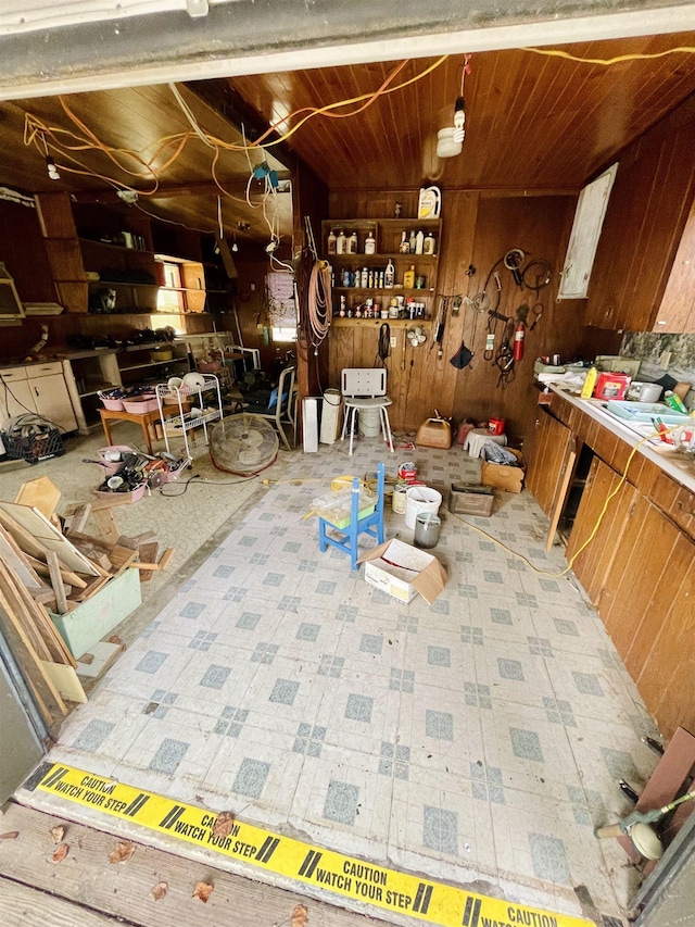 dining space with a workshop area, wooden walls, and wood ceiling