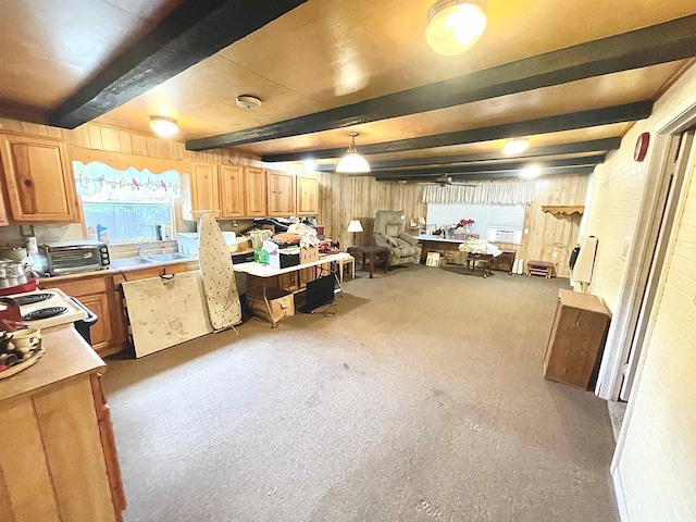 kitchen with white range oven, beamed ceiling, pendant lighting, and light colored carpet