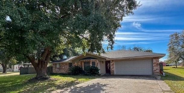 ranch-style home featuring a garage and a front lawn