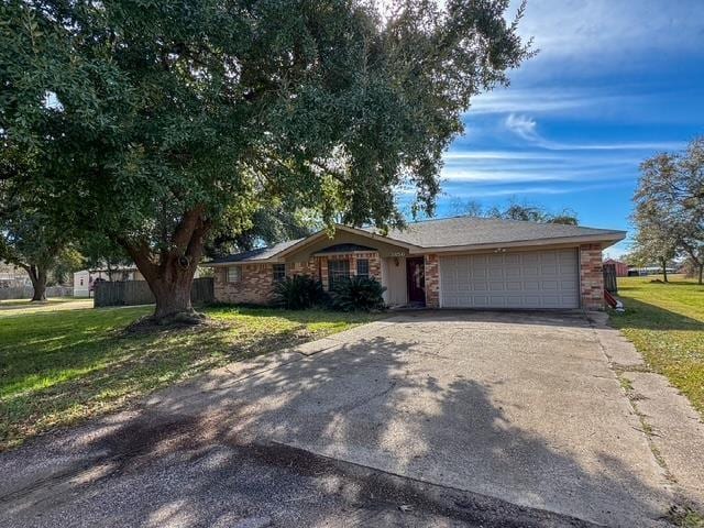 single story home featuring a front lawn and a garage