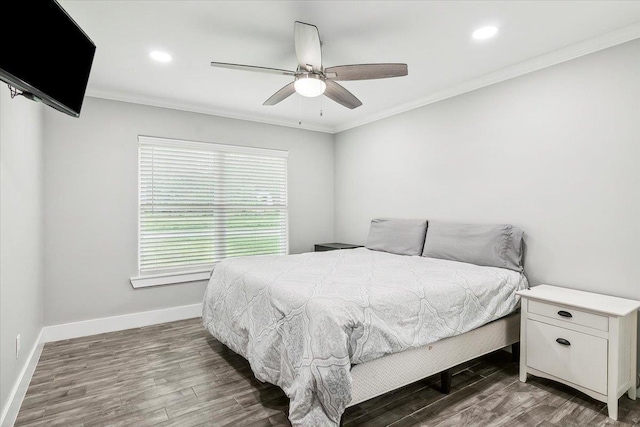 bedroom featuring dark hardwood / wood-style flooring, ceiling fan, and ornamental molding