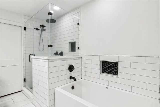 bathroom featuring separate shower and tub