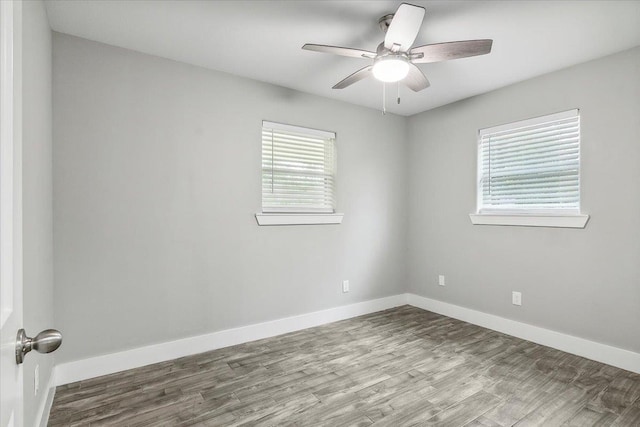 spare room with hardwood / wood-style floors, ceiling fan, and a wealth of natural light