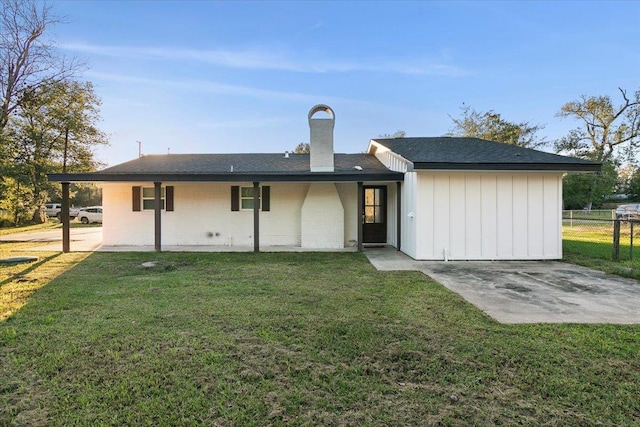 rear view of house with a lawn and a patio area