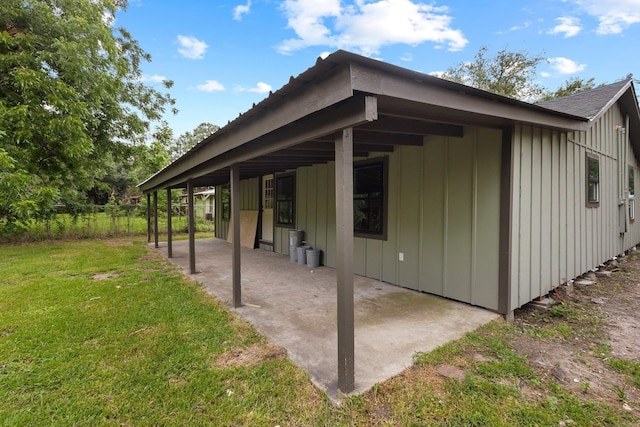 3266 Brent Dr, Orange, TX 77632 - view of home's exterior with board and batten siding, a patio, a yard, and roof with shingles