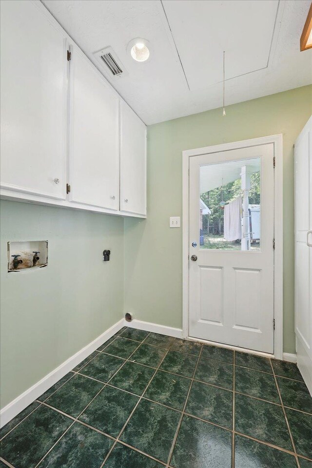 100 Teakwood St, Silsbee, TX 77656 - laundry room with cabinet space, washer hookup, hookup for an electric dryer, attic access, and dark tile patterned flooring