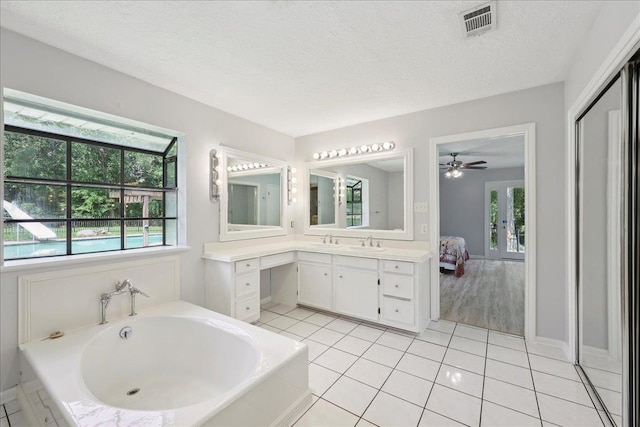 100 Teakwood St, Silsbee, TX 77656 - full bathroom featuring a bath, vanity, tile patterned flooring, ceiling fan, and a textured ceiling