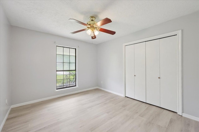 100 Teakwood St, Silsbee, TX 77656 - unfurnished bedroom with light wood-style floors, a textured ceiling, a closet, and a ceiling fan