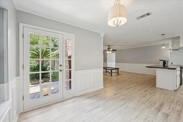 100 Teakwood St, Silsbee, TX 77656 - kitchen featuring a decorative wall, dark countertops, pendant lighting, range hood, and light wood-type flooring