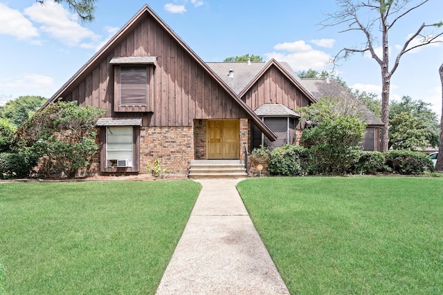 view of front of house featuring a shingled roof, a front yard, and brick siding