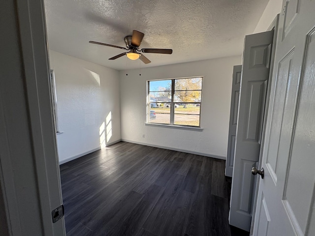 unfurnished room with ceiling fan, dark hardwood / wood-style floors, and a textured ceiling