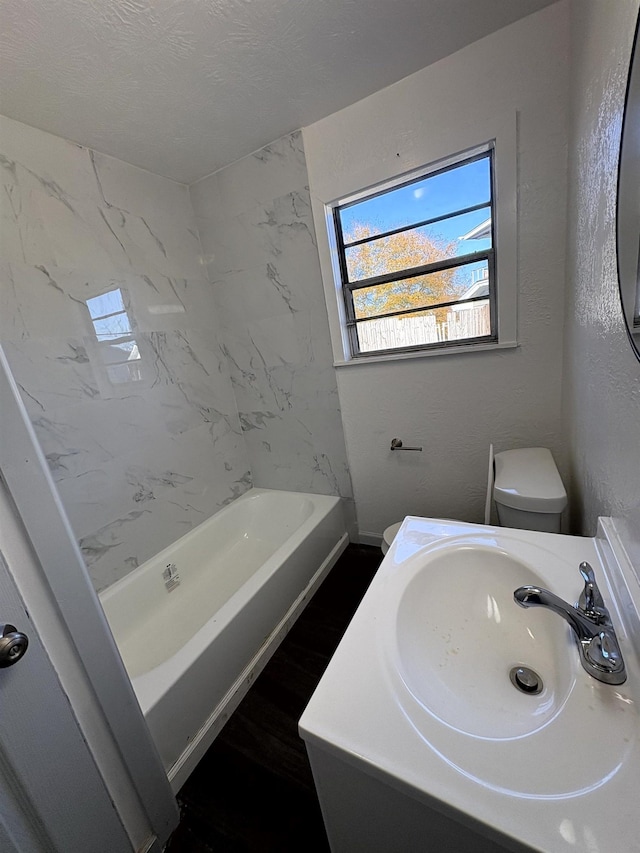 bathroom featuring vanity, toilet, hardwood / wood-style floors, and a textured ceiling