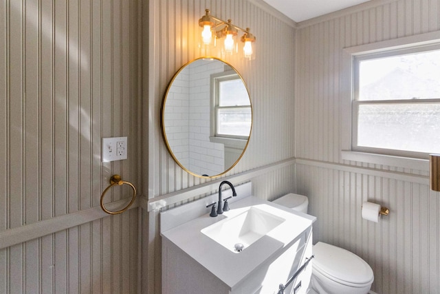 bathroom featuring a wealth of natural light, vanity, and toilet