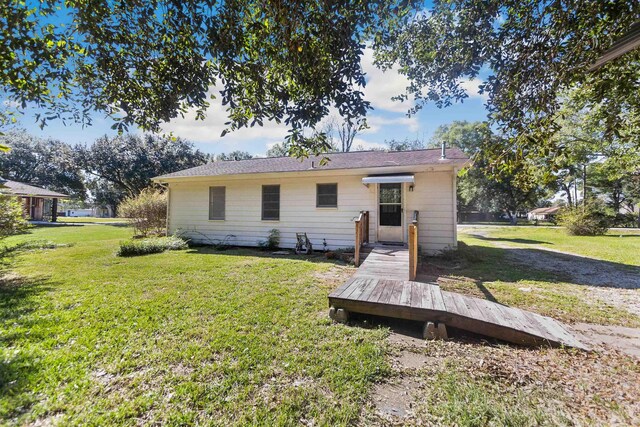 rear view of property with a lawn