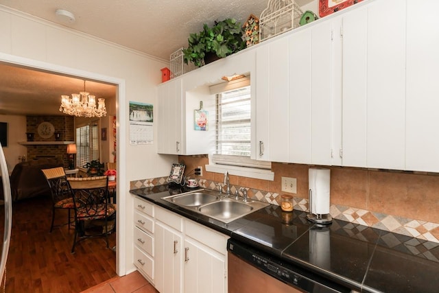 kitchen featuring a chandelier, a textured ceiling, white cabinetry, and a sink