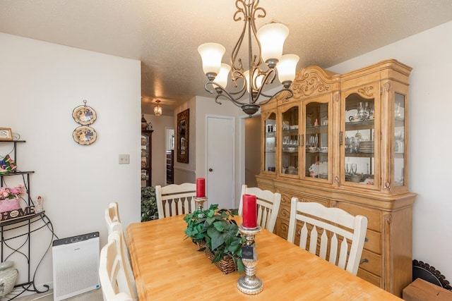 dining space with a textured ceiling and a chandelier