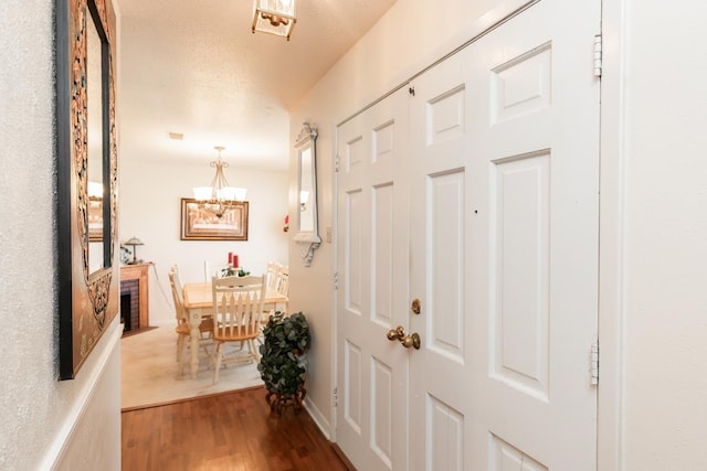 entrance foyer with a notable chandelier, wood finished floors, and baseboards