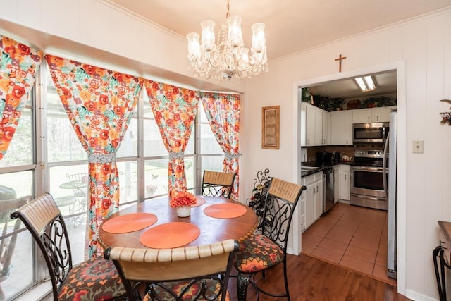 dining space with wood finished floors, a chandelier, and ornamental molding