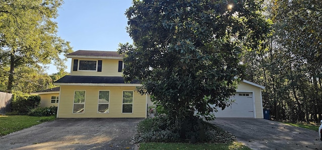 view of property hidden behind natural elements featuring a garage