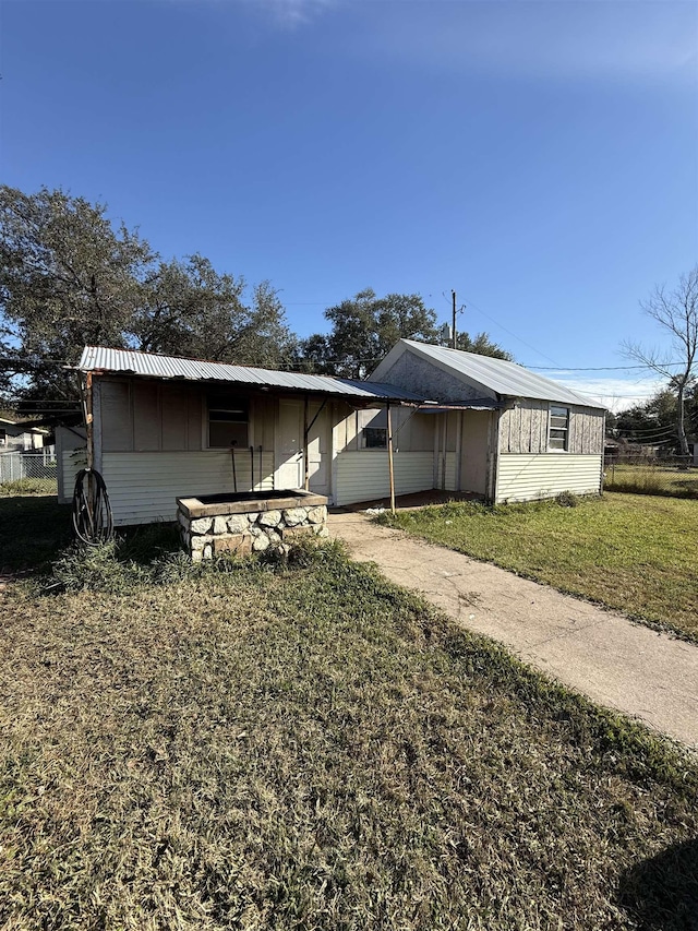 exterior space with a lawn, metal roof, and an attached carport