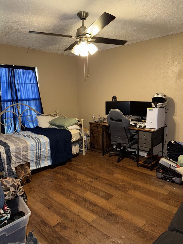 bedroom with a textured ceiling, wood finished floors, and a ceiling fan