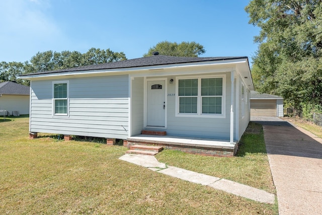 view of front of property featuring an outbuilding, a front yard, and a garage