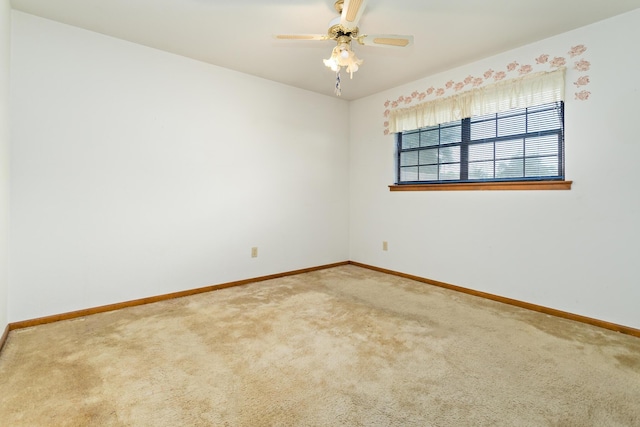 carpeted empty room featuring baseboards and a ceiling fan