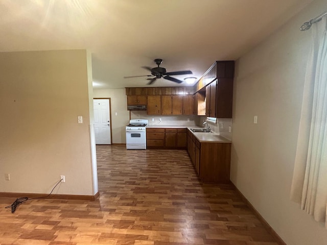 205 Turner Ln, Bridge City, TX 77611 - kitchen featuring white gas range oven, under cabinet range hood, light wood-style flooring, light countertops, and ceiling fan