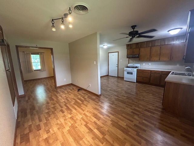 205 Turner Ln, Bridge City, TX 77611 - kitchen with white gas range, light wood-style floors, light countertops, and a ceiling fan