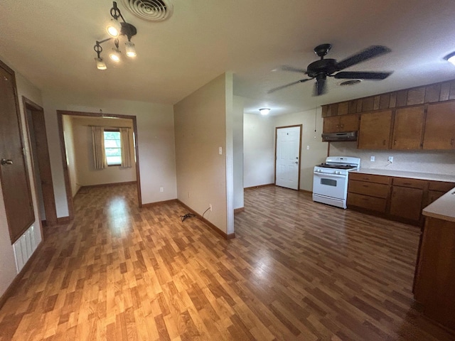 205 Turner Ln, Bridge City, TX 77611 - kitchen featuring white range with gas stovetop, extractor fan, light wood-type flooring, ceiling fan, and light countertops