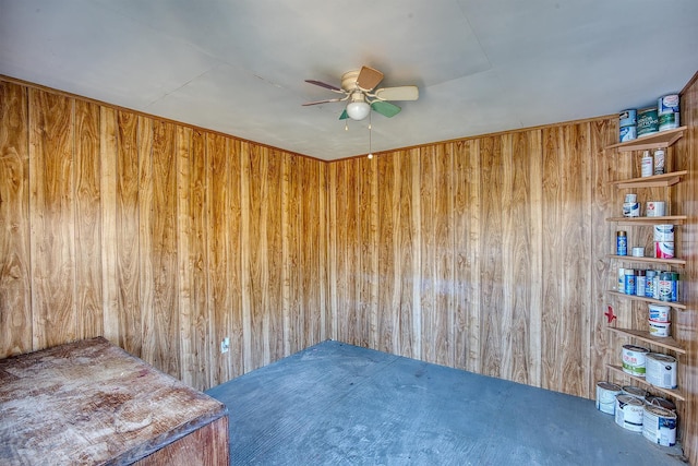 spare room with ceiling fan and wooden walls