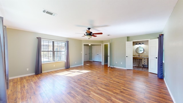 unfurnished bedroom featuring ensuite bathroom, ceiling fan, sink, and dark hardwood / wood-style floors