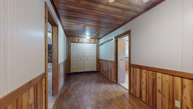 corridor featuring crown molding, dark wood-type flooring, and wooden ceiling