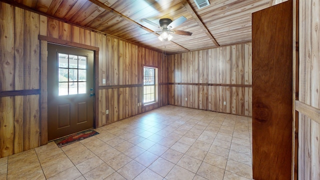 foyer with light tile patterned flooring, ceiling fan, wooden walls, and wood ceiling