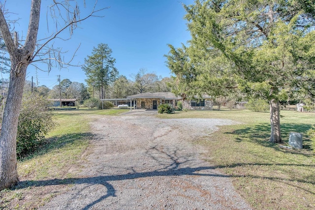 ranch-style house with a front yard and a carport