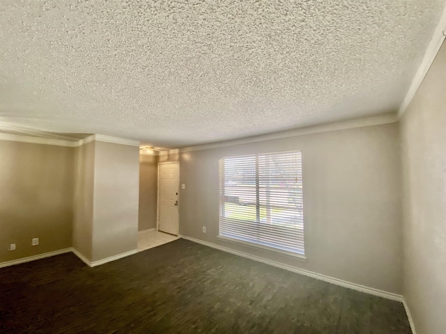 empty room with ornamental molding and a textured ceiling