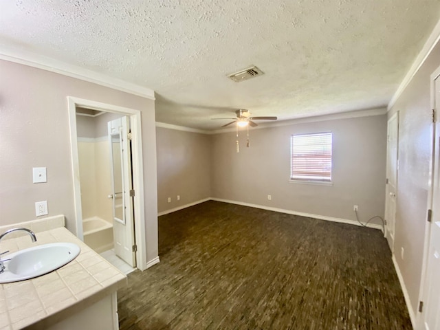 interior space with ceiling fan, a textured ceiling, vanity, and ornamental molding