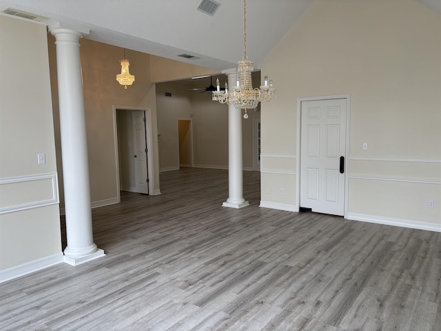unfurnished dining area with a chandelier, visible vents, wood finished floors, and high vaulted ceiling