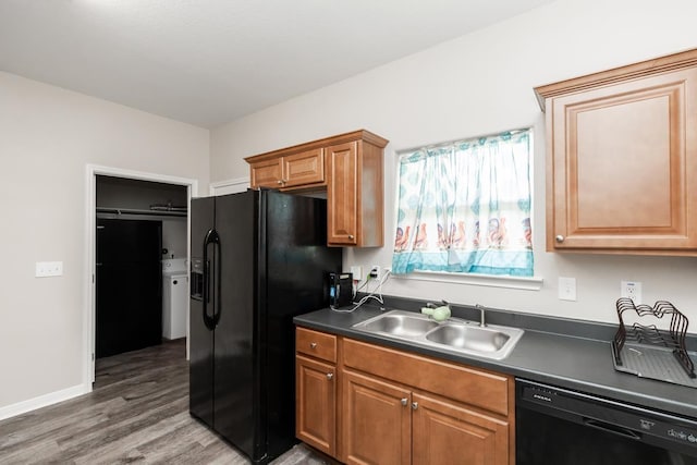 9205 Shepherd Dr, Beaumont, TX 77707 - kitchen with black appliances, a sink, dark countertops, wood finished floors, and washing machine and clothes dryer