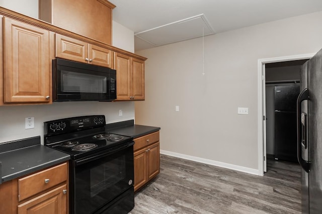 9205 Shepherd Dr, Beaumont, TX 77707 - kitchen featuring black appliances, dark countertops, wood finished floors, baseboards, and brown cabinets