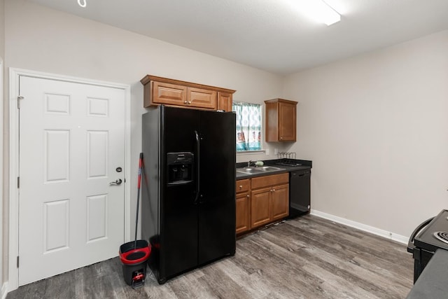9205 Shepherd Dr, Beaumont, TX 77707 - kitchen featuring black appliances, wood finished floors, and brown cabinets