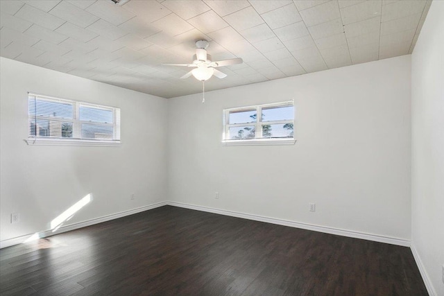 empty room with dark hardwood / wood-style floors, plenty of natural light, and ceiling fan