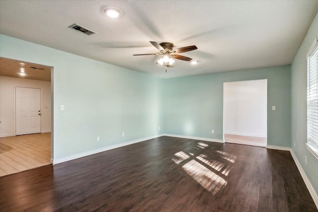 unfurnished room featuring a textured ceiling, ceiling fan, and dark hardwood / wood-style floors