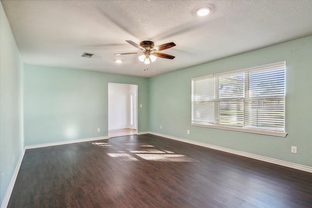 empty room with a textured ceiling, dark hardwood / wood-style floors, and ceiling fan