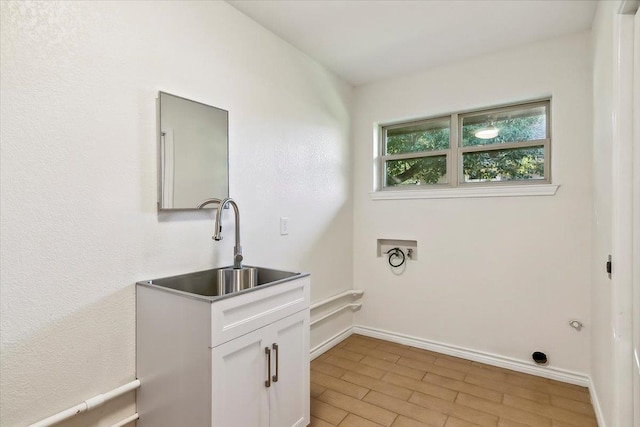 washroom featuring washer hookup, cabinets, light wood-type flooring, and sink