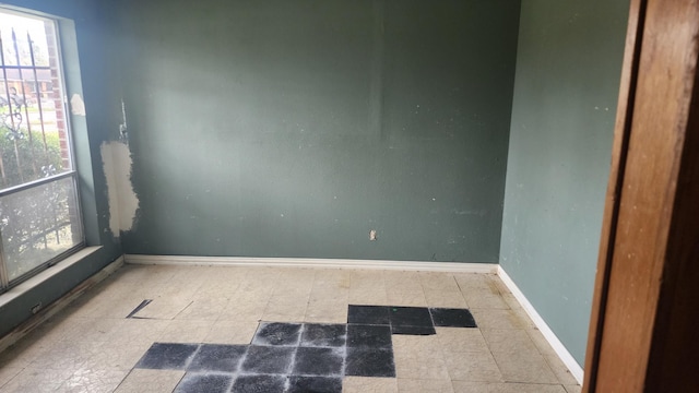 unfurnished room featuring tile patterned floors and baseboards